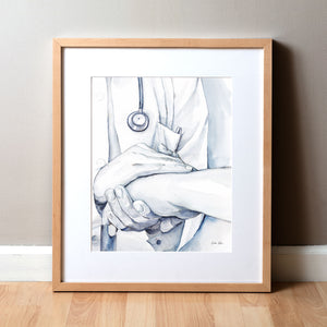 Framed watercolor painting of a doctor holding a patient’s hand in comfort