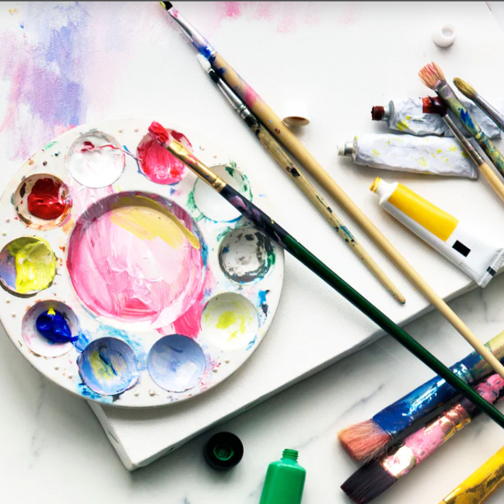 Paint pallet, brushes and paints on a canvas