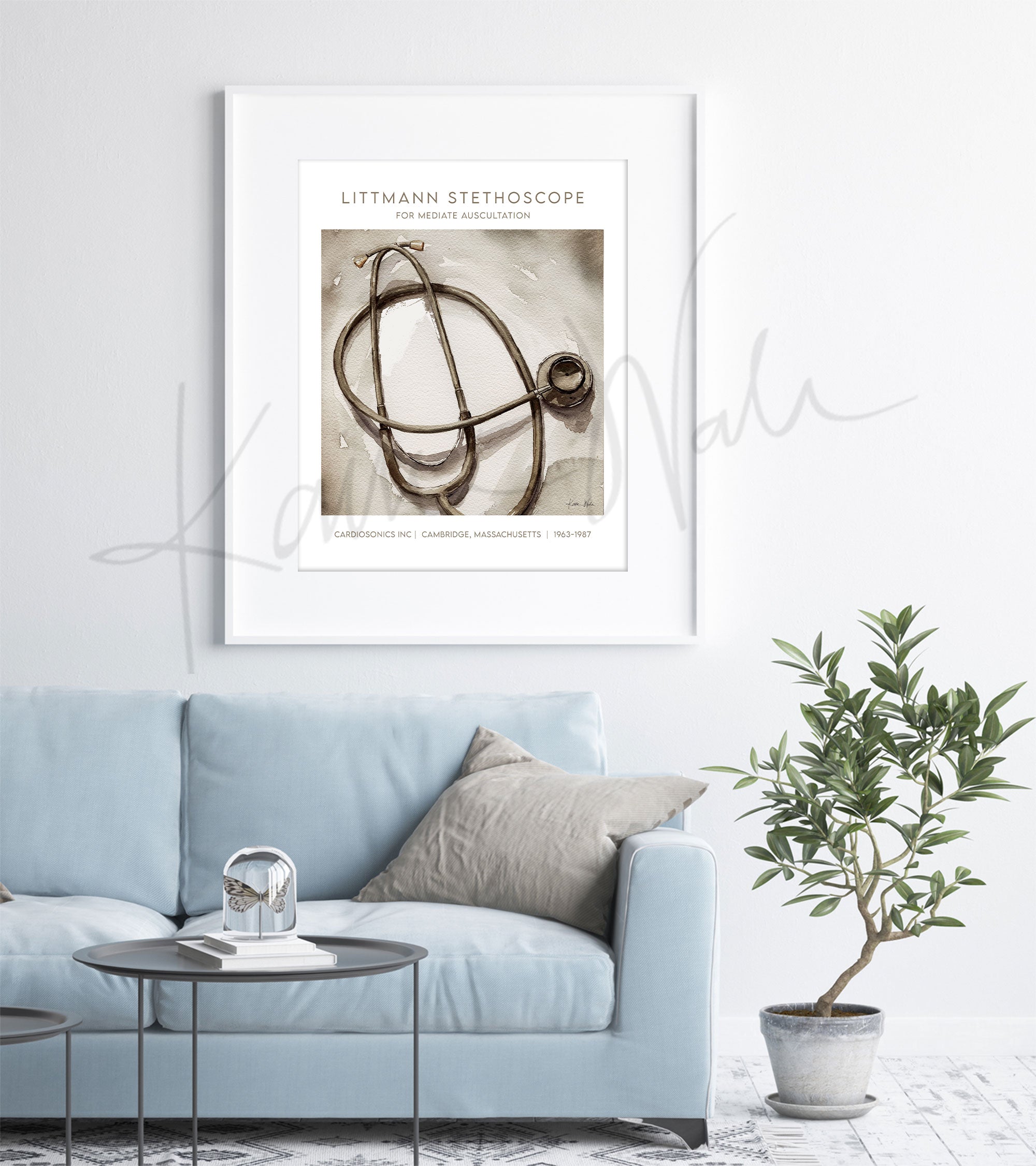 Framed watercolor painting of a Littmann stethoscope with information on it in an antique style. The painting is hanging over a blue couch.