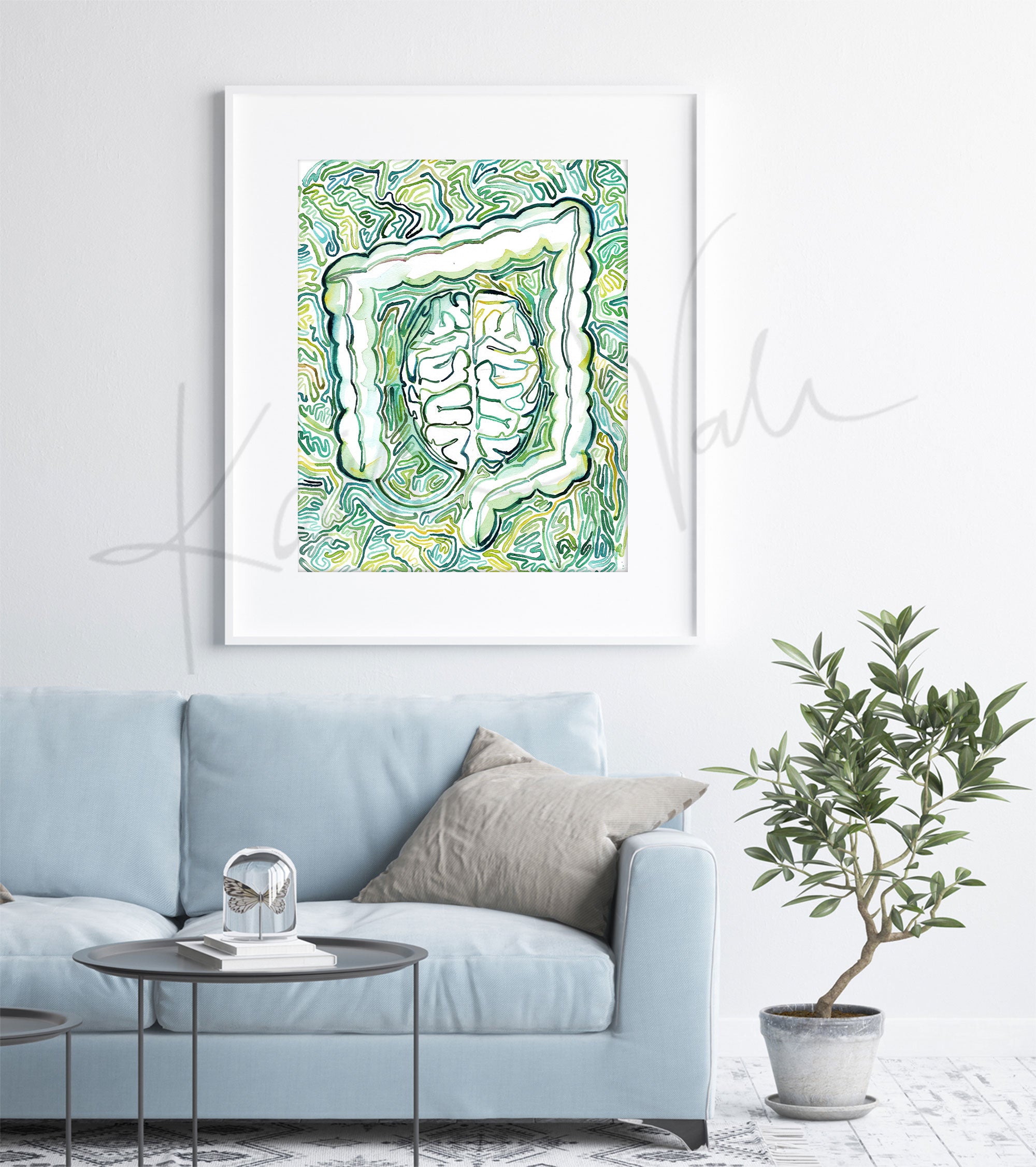 Framed watercolor painting of a portrayal of the gut-mind-body connection. The painting is hanging over a blue couch.