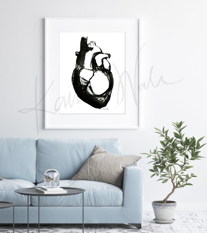 Framed black and white abstract anatomy art of heart anatomy art piece on a wall above a light blue sofa.
