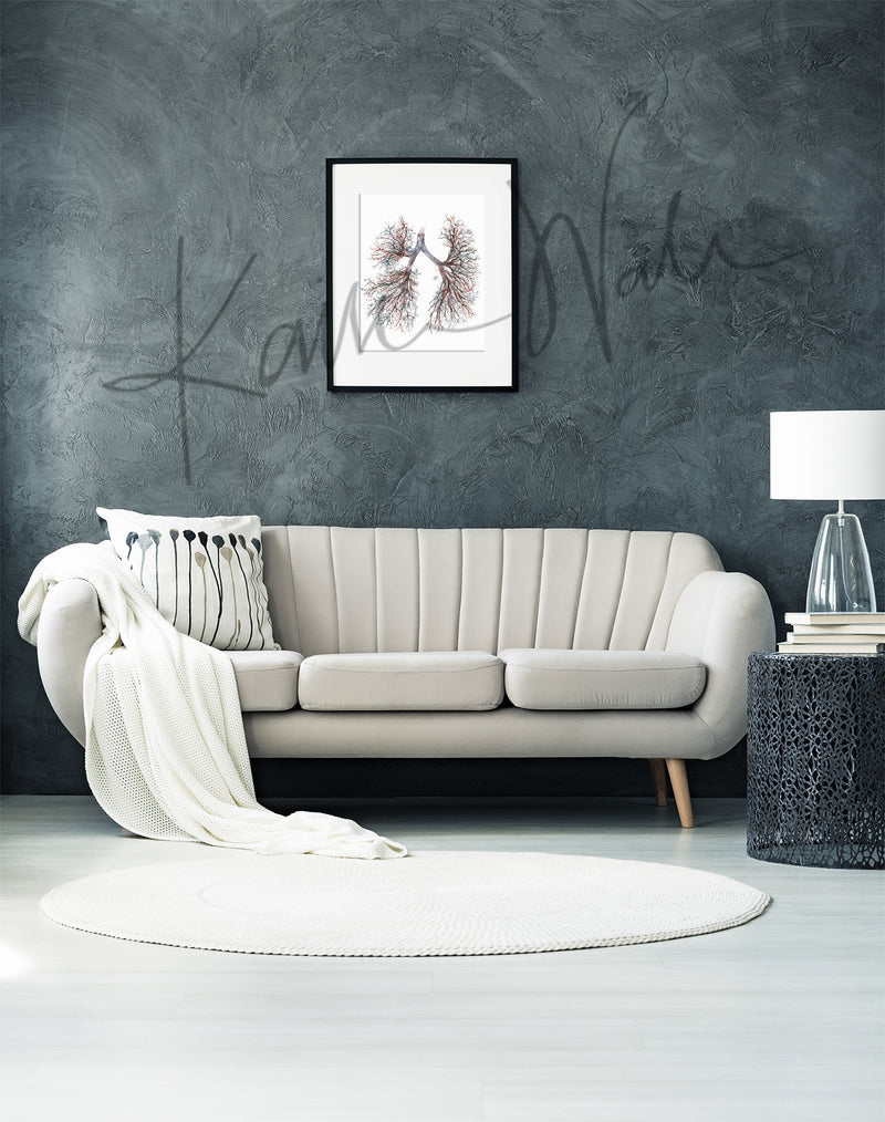 Modern doctors office room with a white sofa, decorative pillow, and framed anatomy artwork on a gray wall.