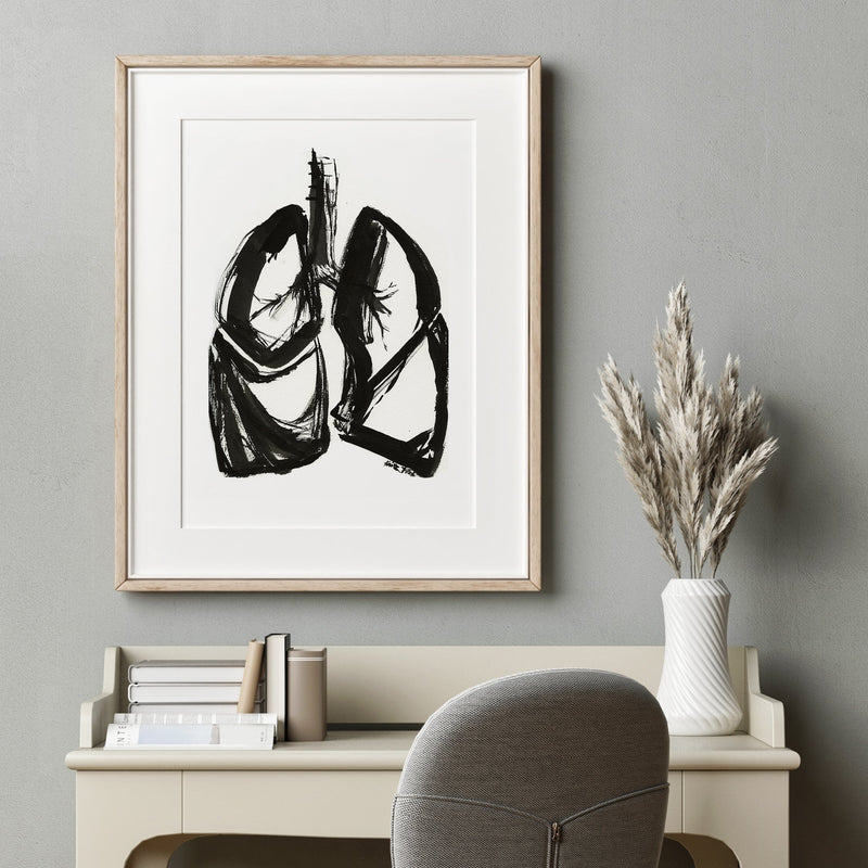 Framed artwork of lungs on a wall above a desk with a chair. Doctor gift