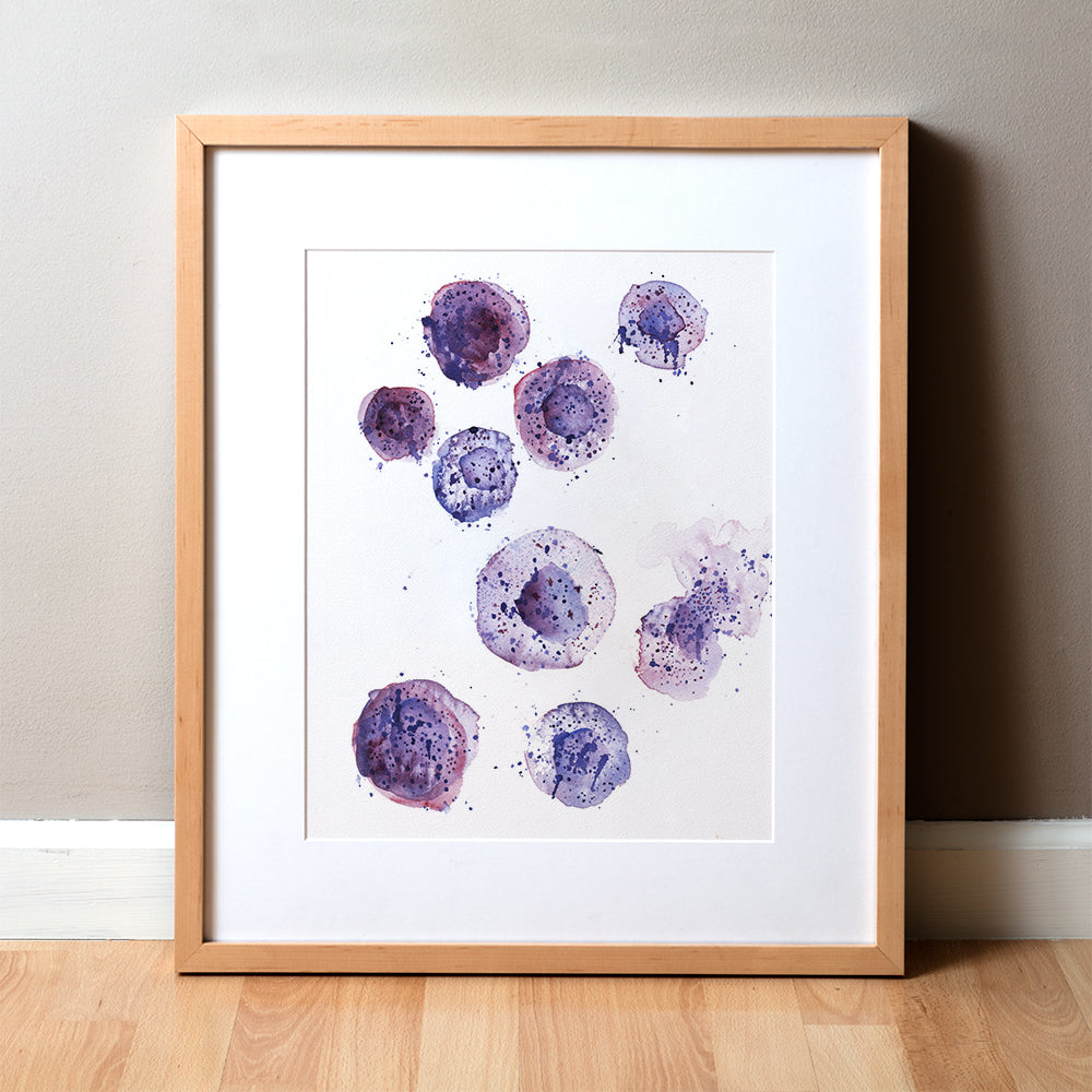 A framed watercolor print depicting purple mast cells displayed on a neutral background wall.