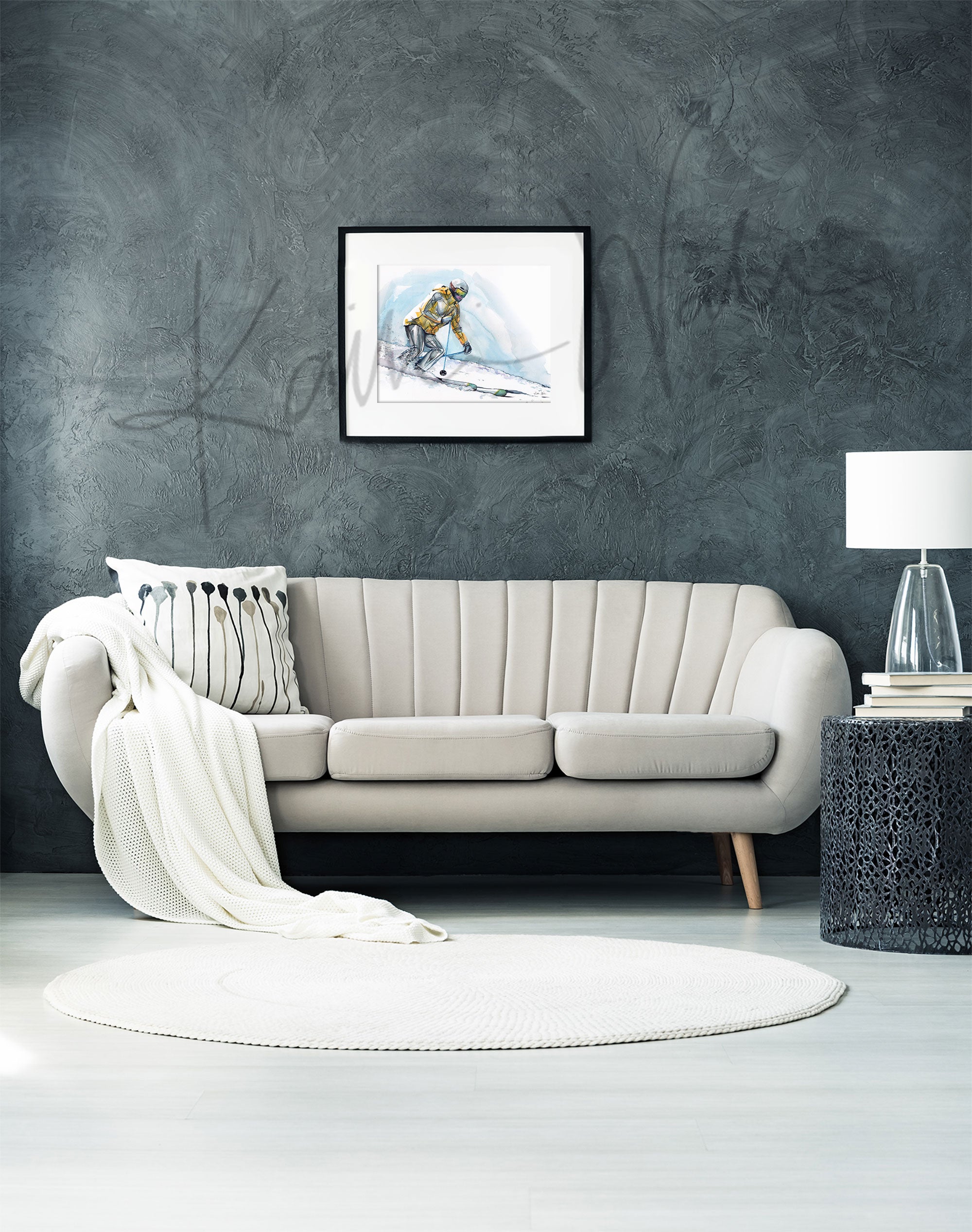 Framed watercolor painting of a skier going down a ski hill with their muscle anatomy showing under their clothing. The painting is hanging over a white couch.