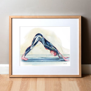 Framed watercolor painting of a woman doing a down dog yoga pose and shows her muscular anatomy within the pose. 