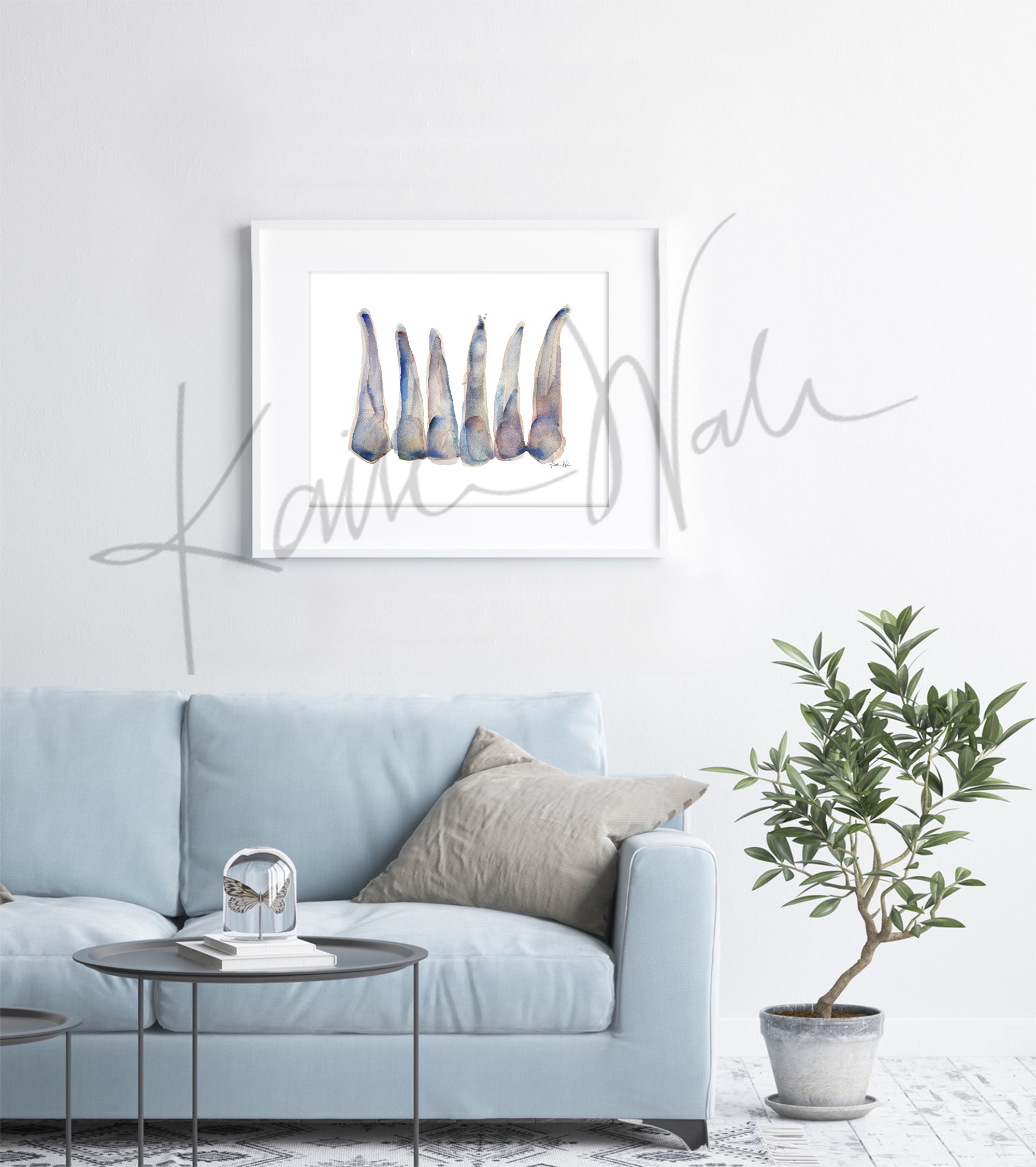 Framed watercolor painting of maxillary incisors in blue, gray and soft, subtle reds. The painting hangs over a blue couch.