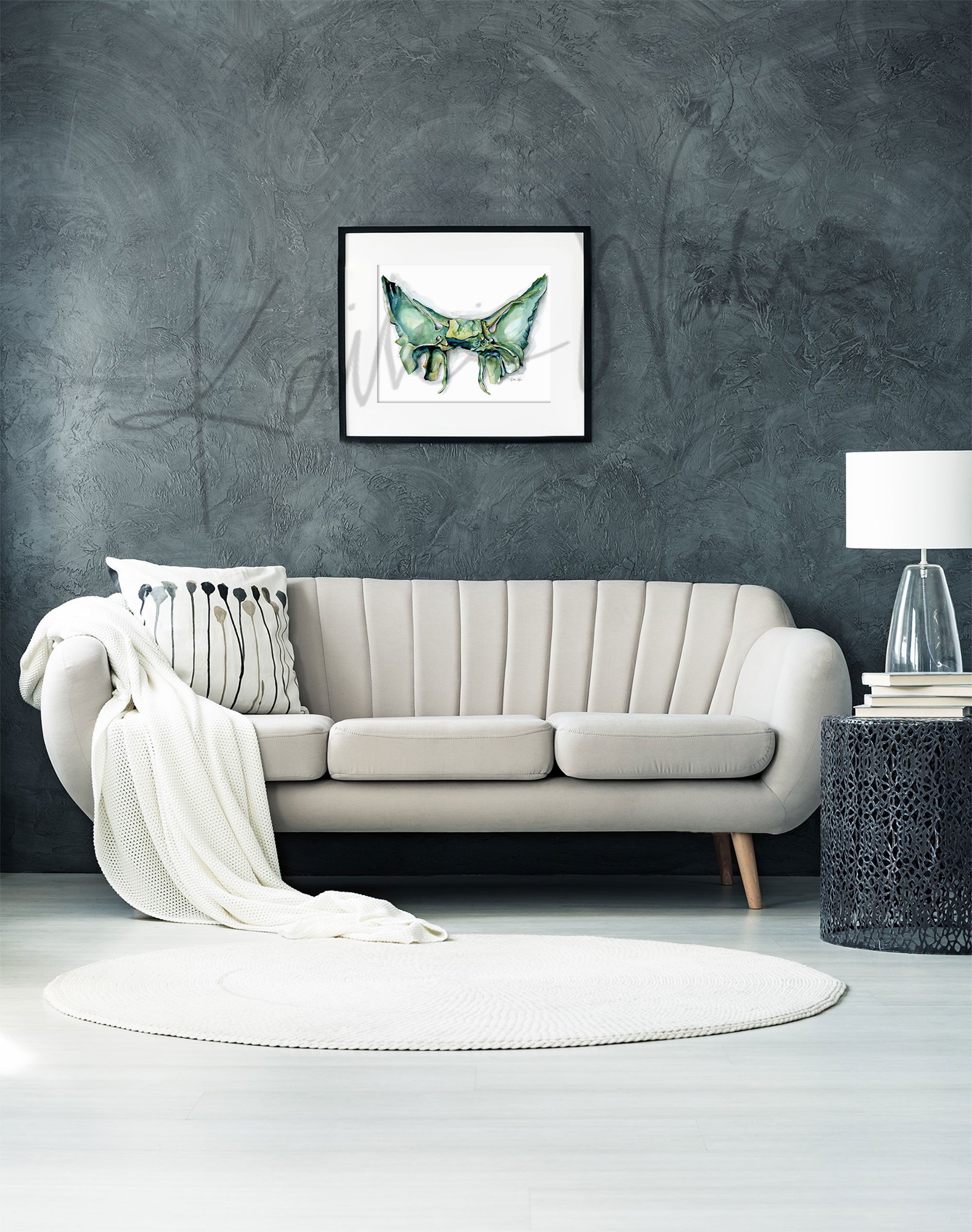 Framed watercolor painting of the sphenoid bone. The painting is hanging over a white couch.