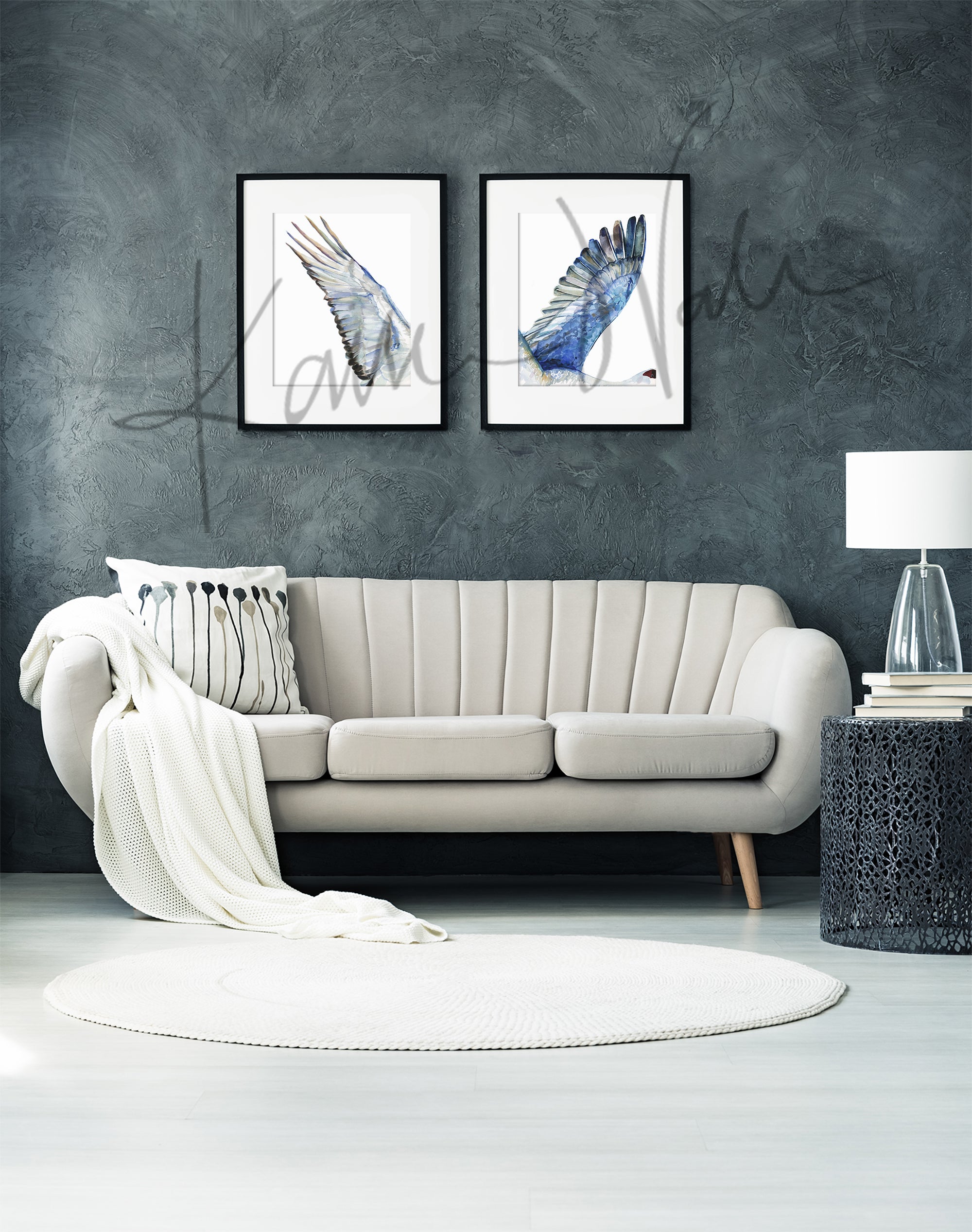 Framed watercolor diptych of a crane's wings. The paintings are hanging over a white couch.