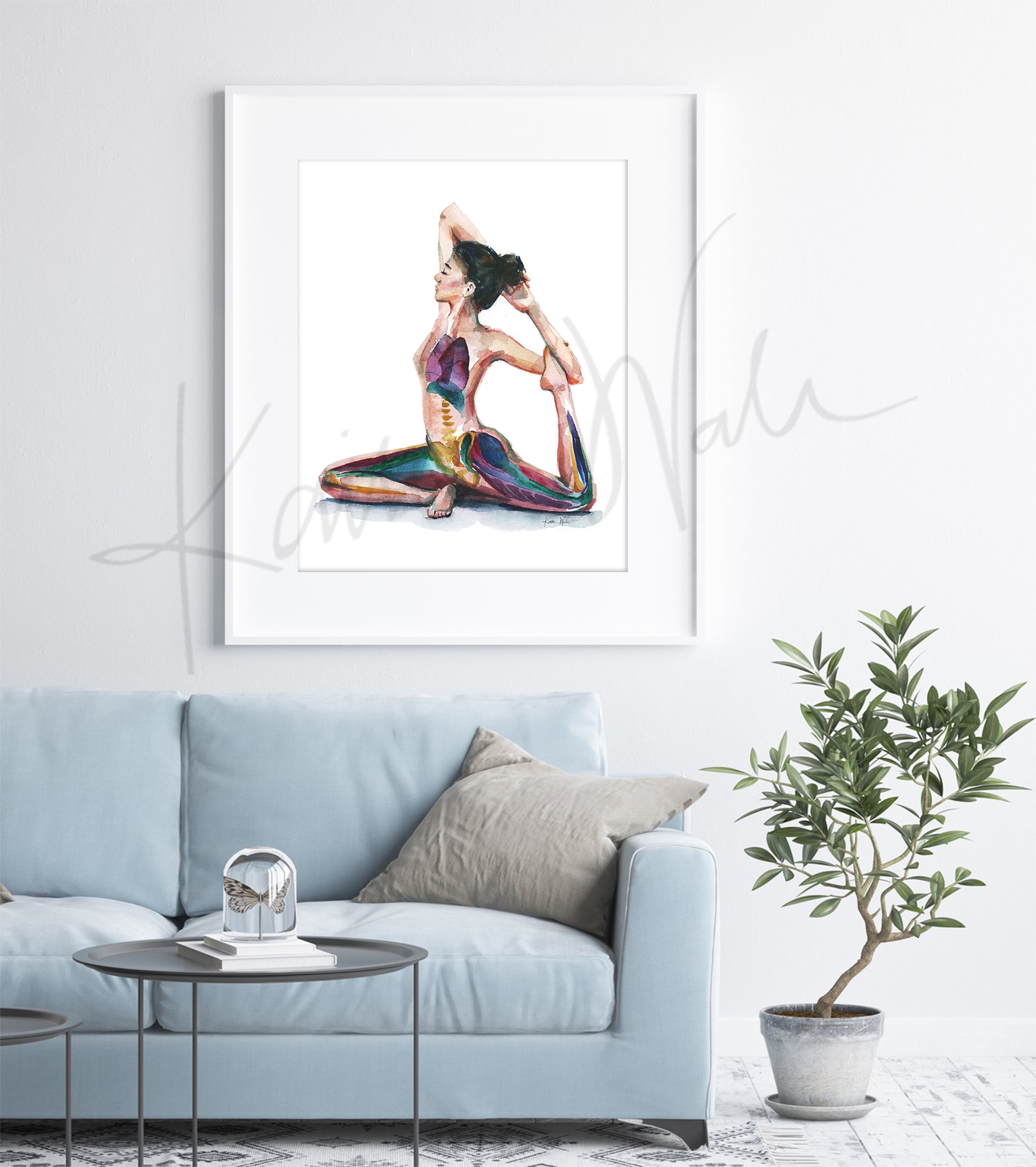 Framed watercolor painting of a woman with her eyes closed in a seated yoga position stretching her leg behind her. The painting is hanging over a blue couch.