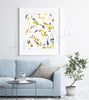 Framed watercolor painting of mesenchymal stem cells. The painting is hanging over a blue couch.