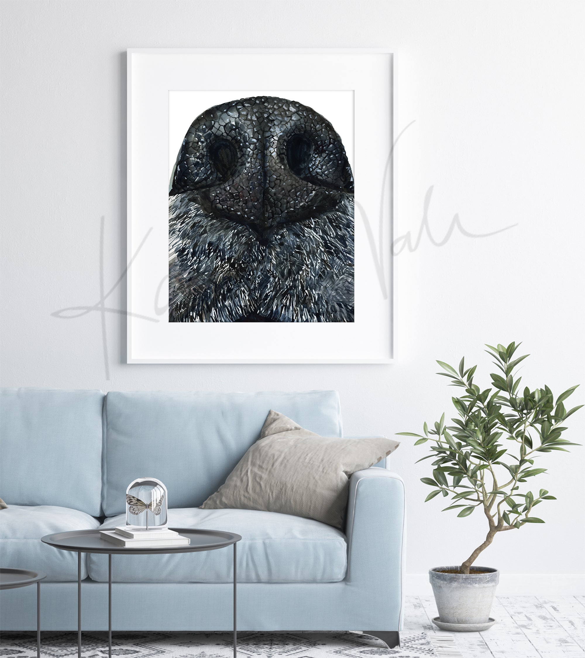 Framed watercolor painting of a zoomed in perspective of a dog’s nose.  The painting is hanging over a blue couch.