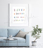 Framed watercolor painting of the karyotype of someone with Down Syndrome. The painting is hanging over a blue couch.