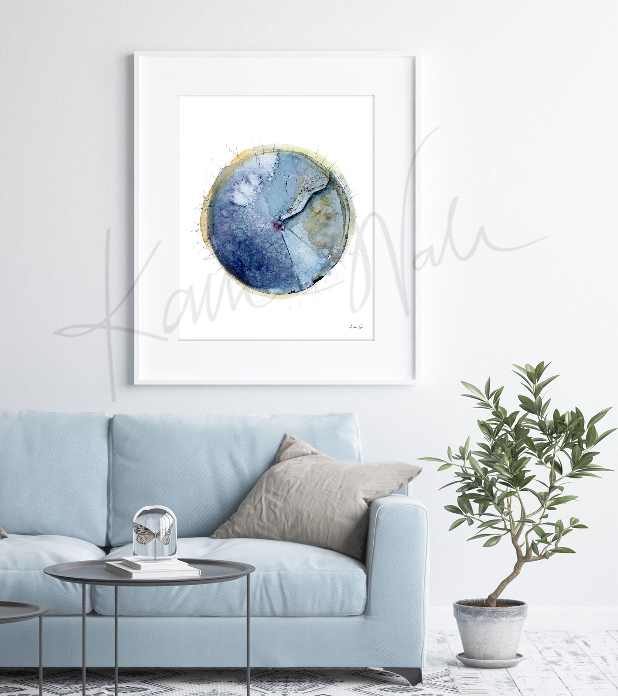 Framed watercolor painting of an eardrum. The painting is hanging over a blue couch.