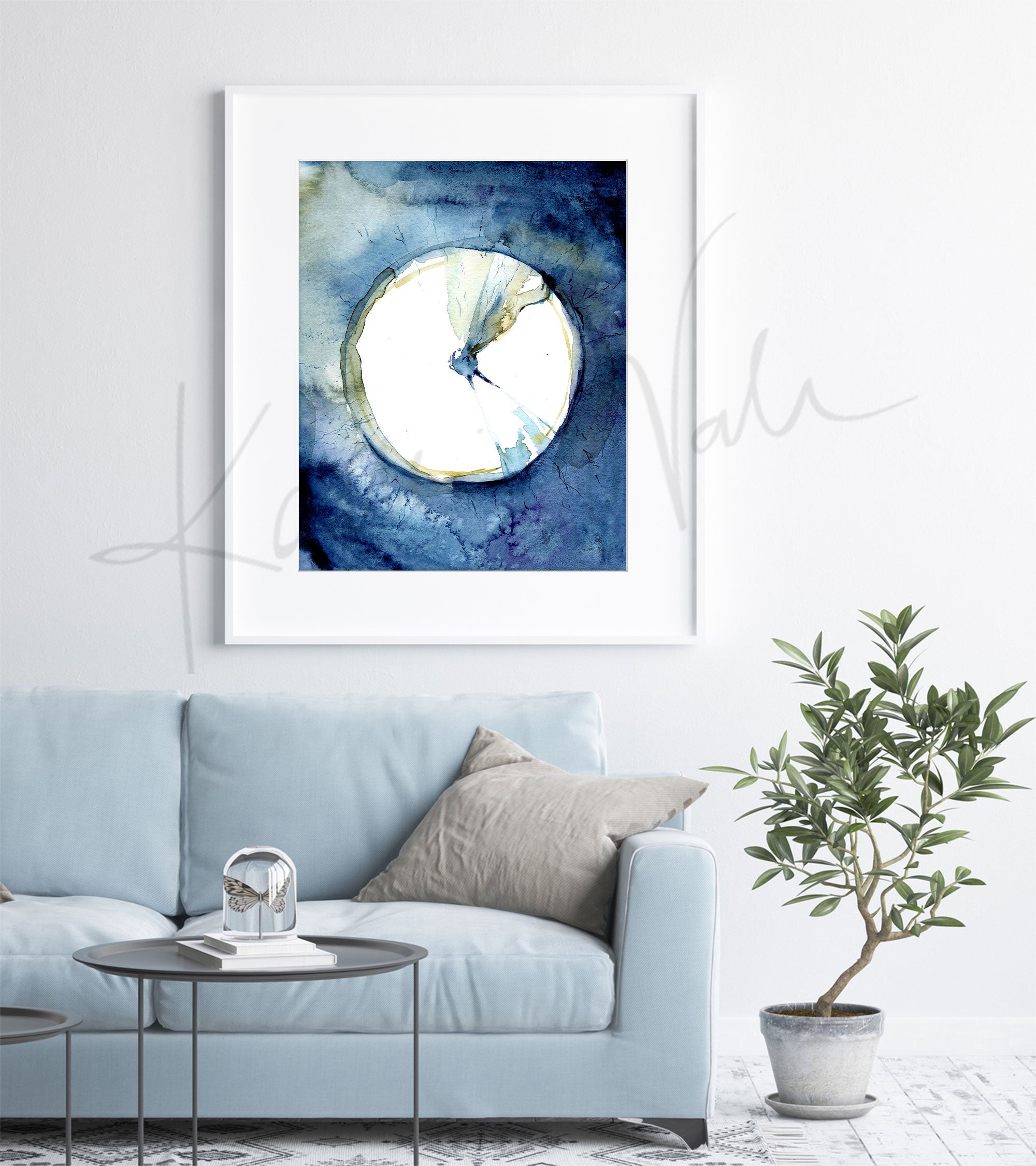 Framed watercolor painting of an eardrum. The painting is hanging over a blue couch.