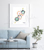 Framed watercolor painting of the estrogen hormone structure. The painting is hanging over a blue couch.
