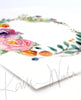 Angled view of a watercolor painting of a flower wreath.