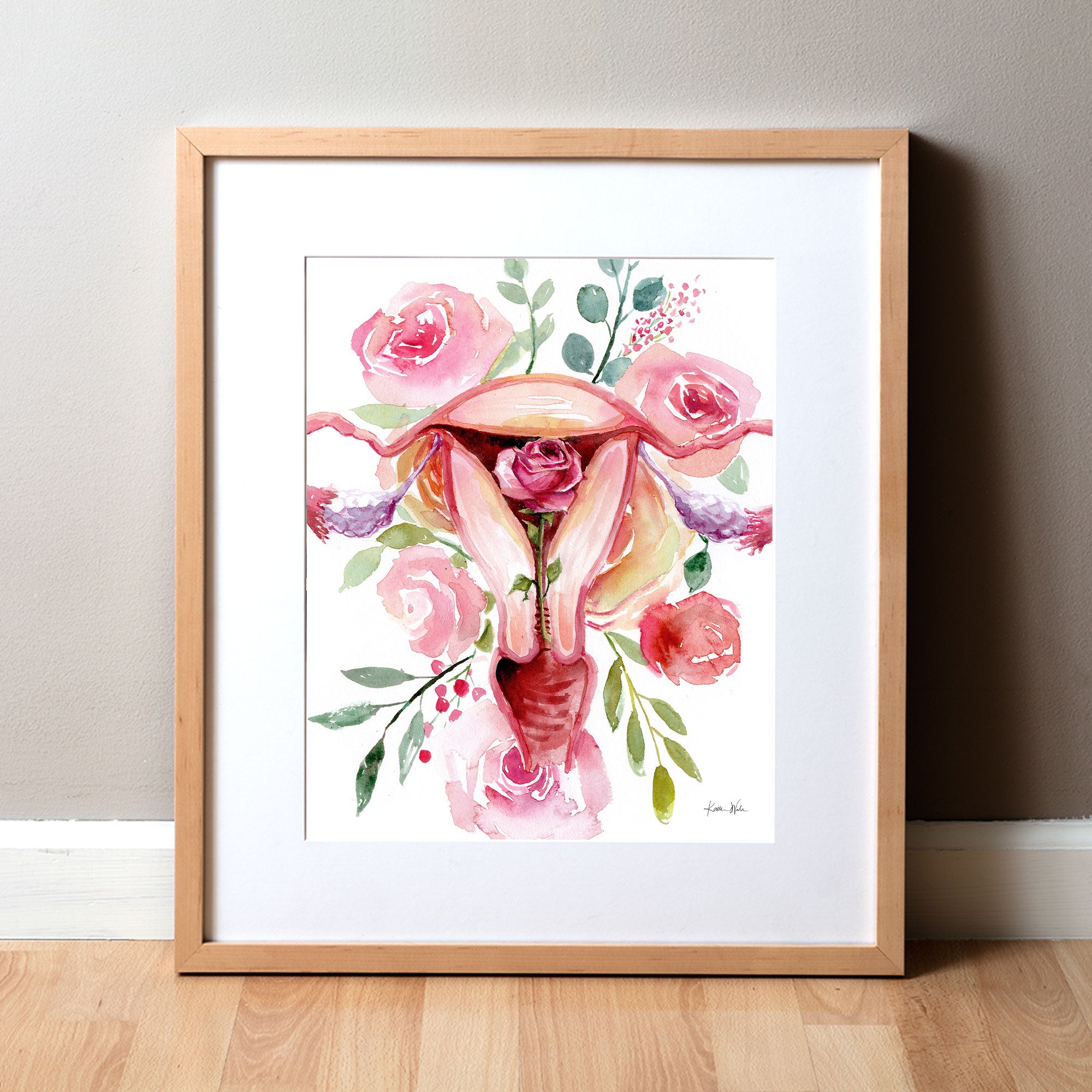 Framed watercolor painting of a uterus with flowers around.