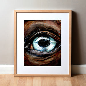 Framed watercolor painting of a zoomed in perspective of a horse eye. The iris is light blue and the horse is painted a warm brown.