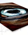 Unframed watercolor painting of a zoomed in perspective of a horse eye. The iris is light blue and the horse is painted a warm brown. The print is at an angle.