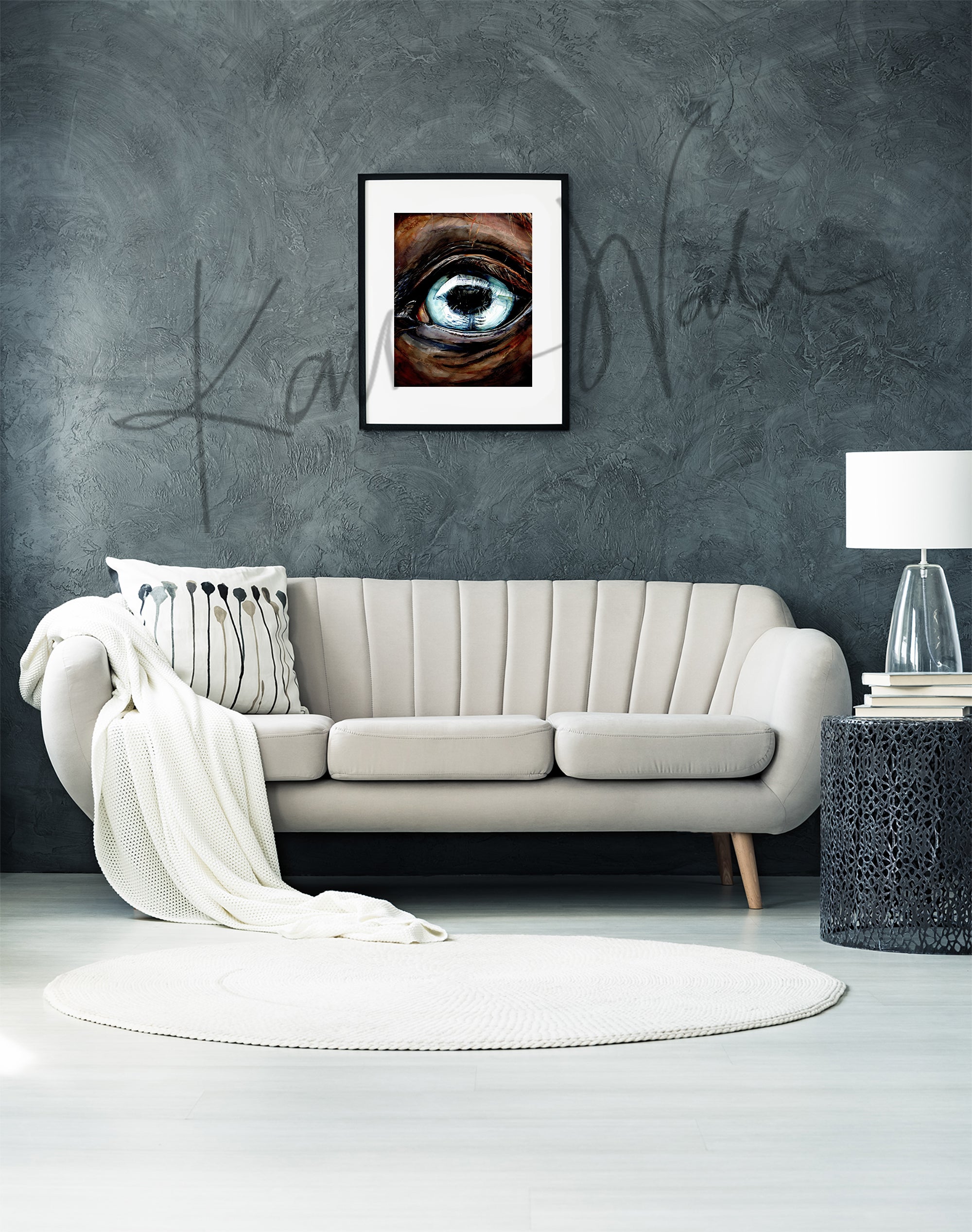 Framed watercolor painting of a zoomed in perspective of a horse eye. The iris is light blue and the horse is painted a warm brown. The painting is hanging over a beige couch.