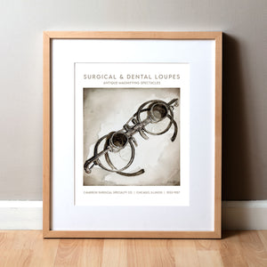 Framed watercolor painting of a set of antique surgical loupes.