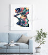 Framed colorful, abstract watercolor painting of a lung dissection in navy, green, yellow, and pink. The painting is hanging over a blue couch. 