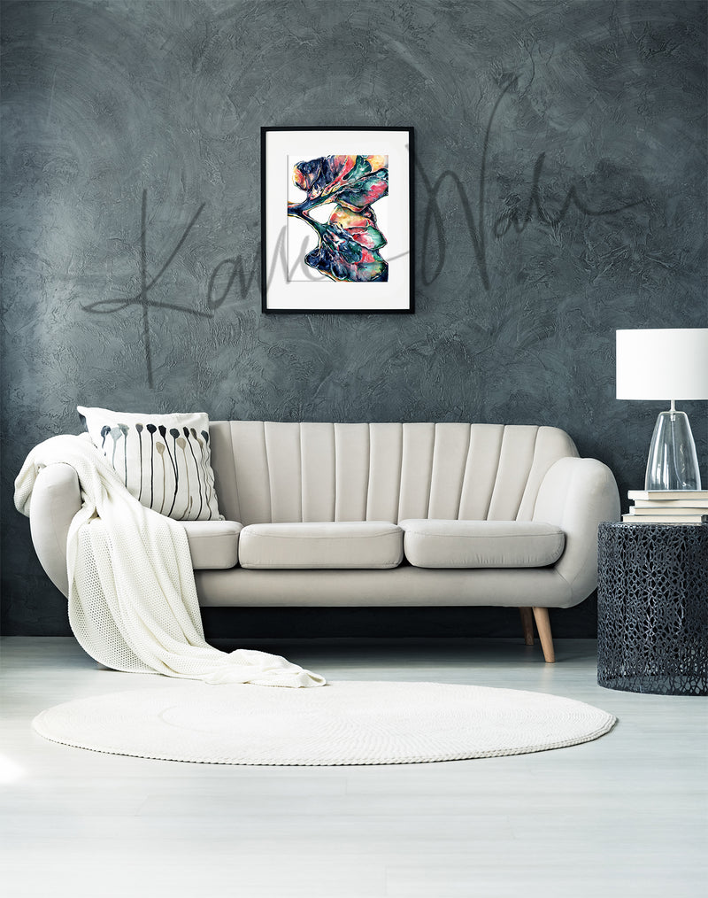 Framed colorful, abstract watercolor painting of a lung dissection in navy, green, yellow, and pink. The painting is hanging over a white couch.