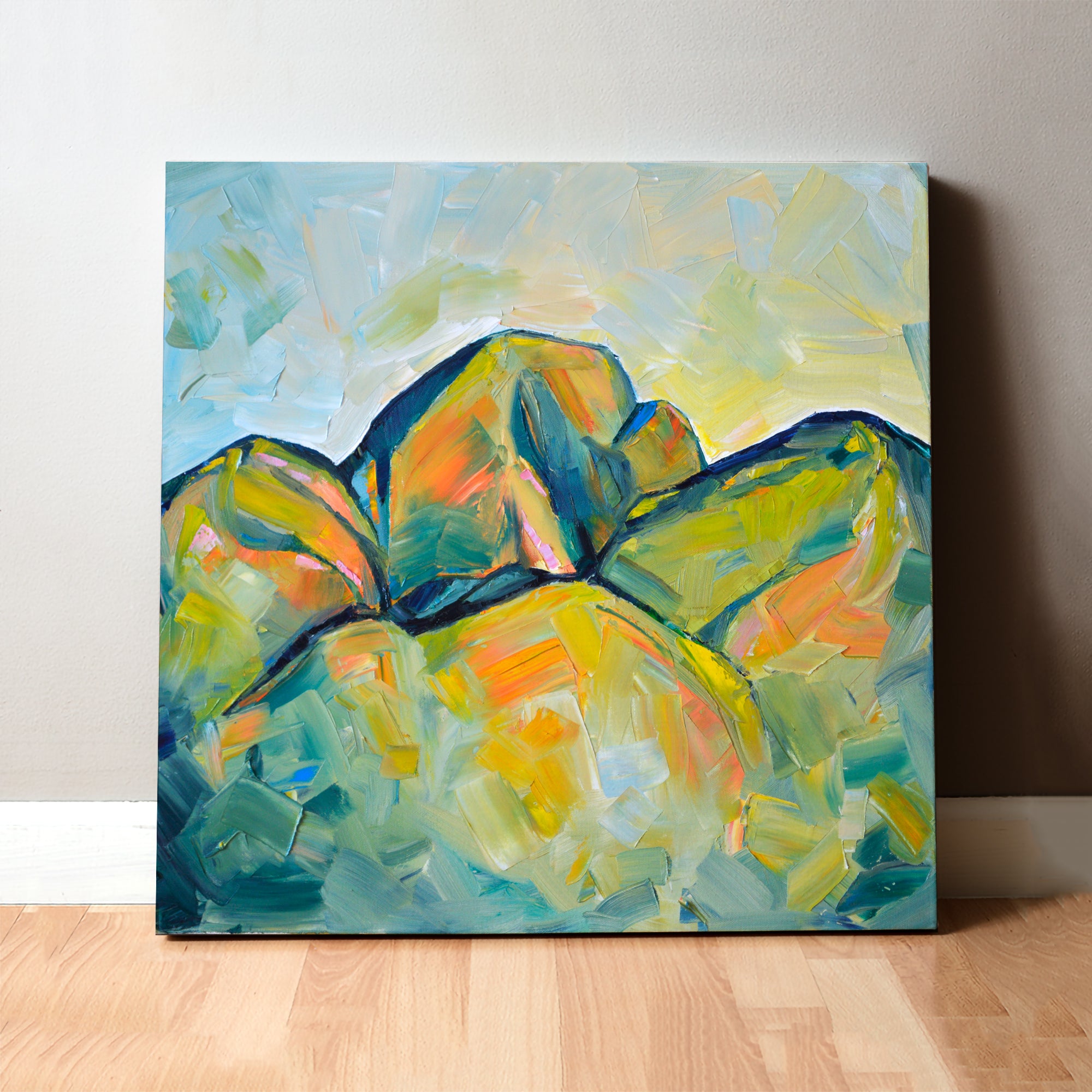 Oil painting of an abstract molar tooth painted to look like mountains. The canvas painting leans on a gray wall.
