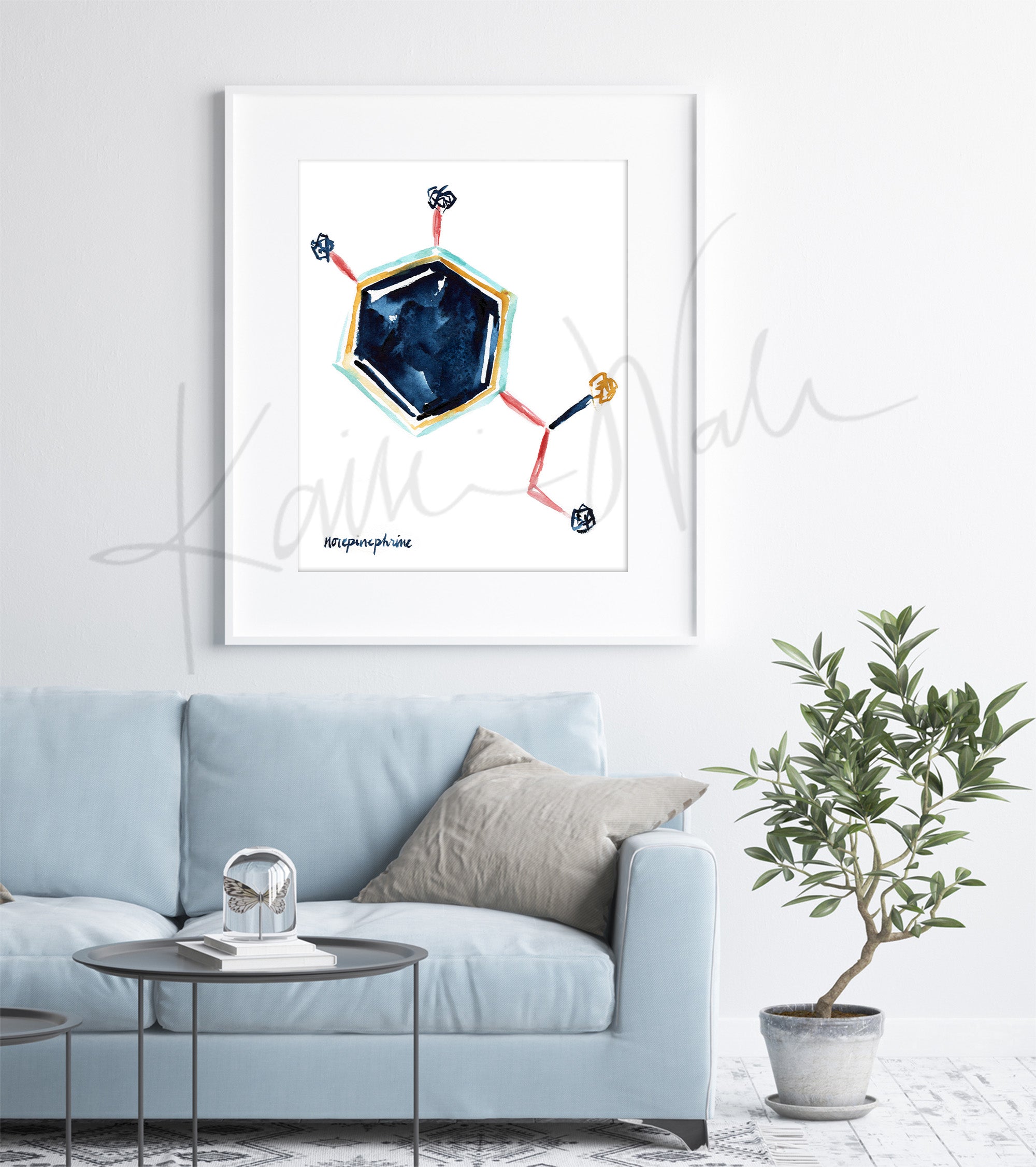 Framed watercolor painting of the norepinephrine hormone structure in blues, yellow and reds. The painting is hanging over a blue couch.
