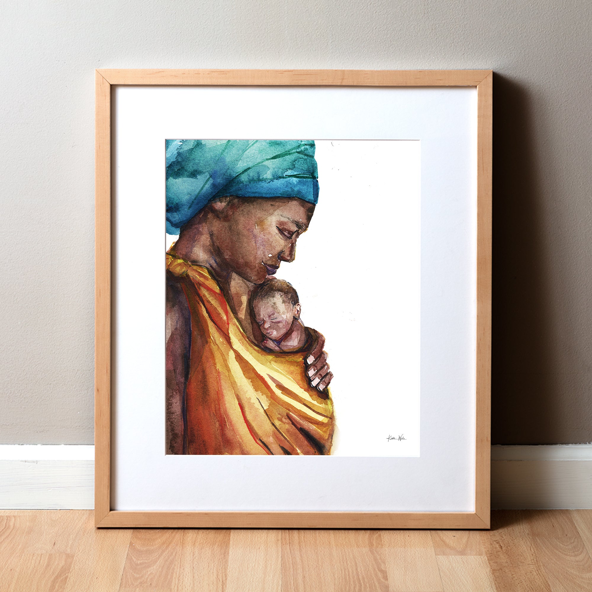 Framed watercolor painting of an african woman holding her premature infant. She is wearing a teal head wrap and is wearing her child in an orange wrap.