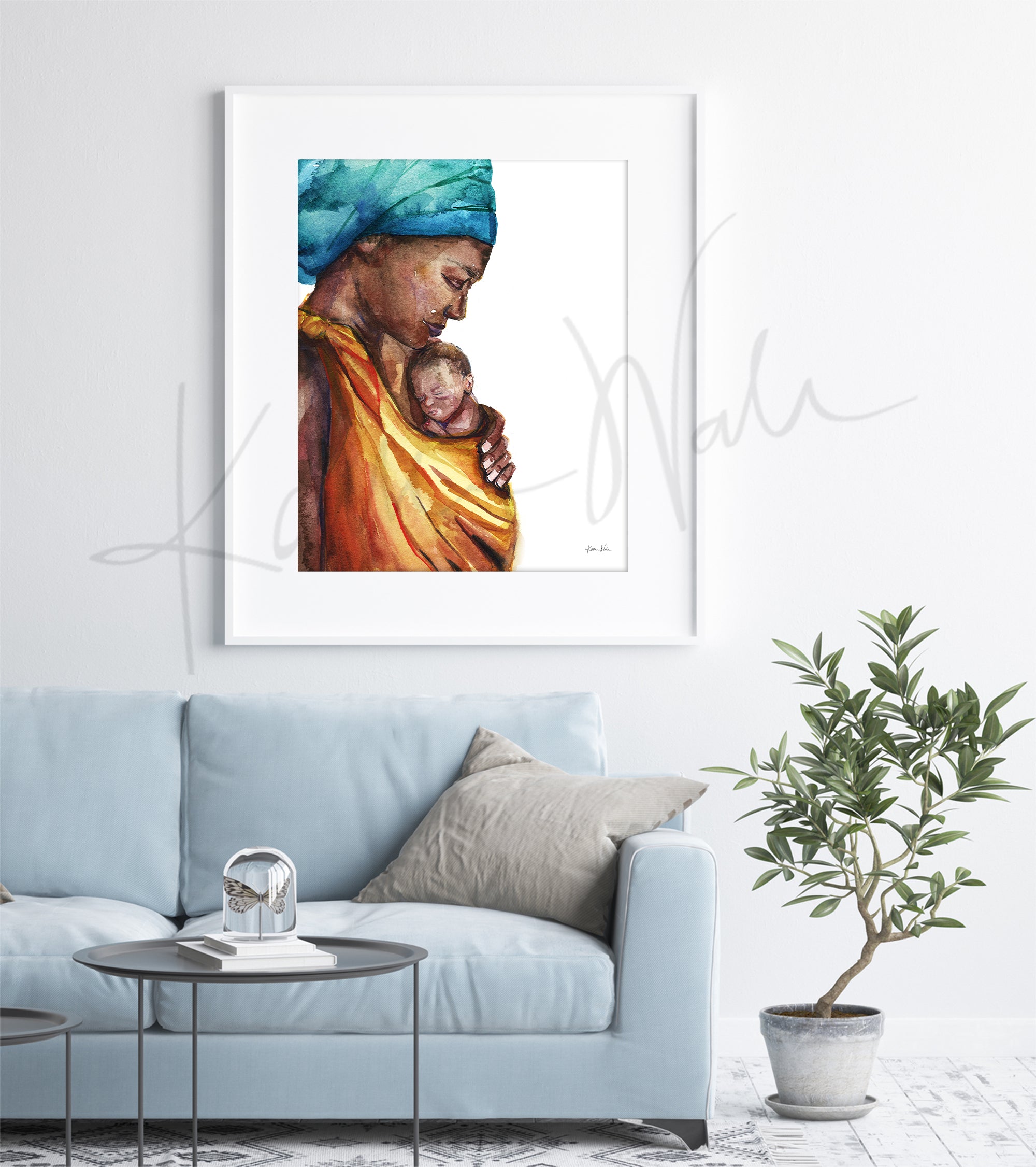 Framed watercolor painting of an african woman holding her premature infant. The painting is hanging over a blue couch.