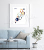 Framed watercolor painting of the progesterone hormone molecular structure. The painting is hanging over a blue couch.