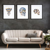 Framed watercolor painting set of a top view of an exploded skull , a side view of an exploded skull, and a three quarter view skull.