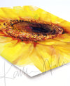 Unframed watercolor painting of a sunflower in solidarity with Ukraine. The painting is angled to the back of the image.
