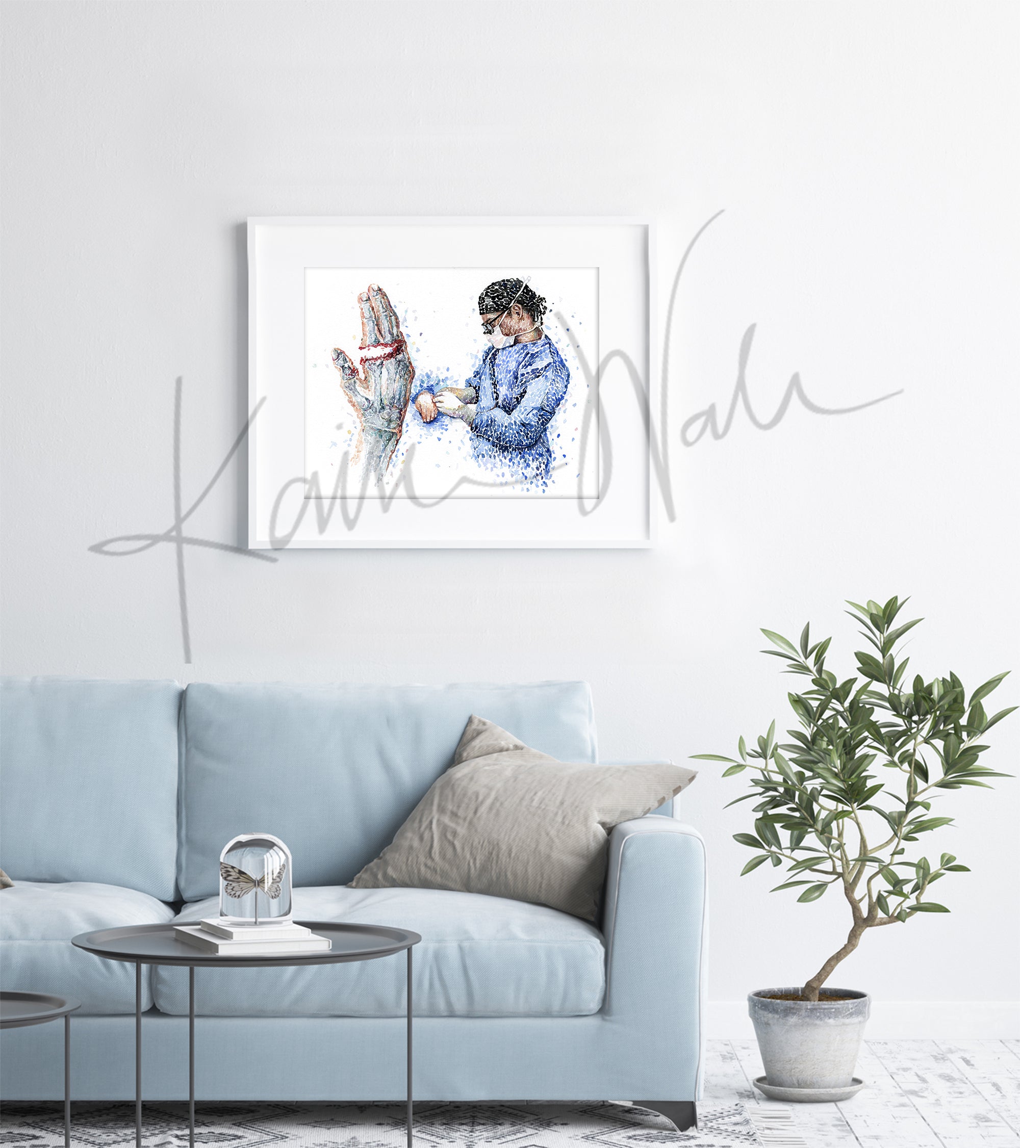 Framed watercolor painting of a finger amputation surgery. The painting is hanging over a blue couch.