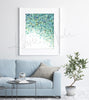 Framed watercolor painting of the tapetum lucidum tissue in animal eyes. The painting is hanging over a blue couch. 