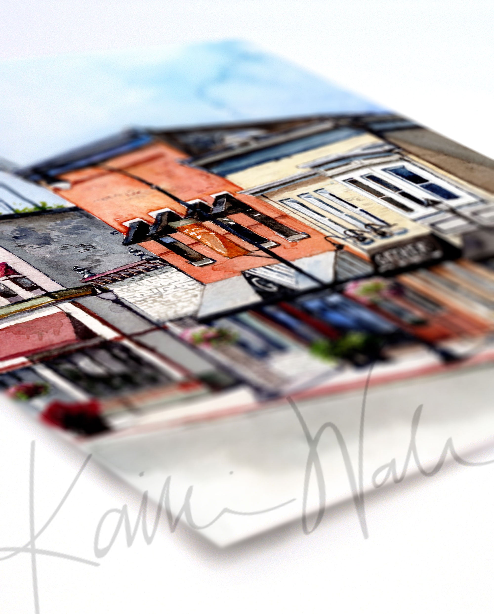 Angled view of a watercolor painting of buildings on Main Street in Waunakee, Wisconsin.