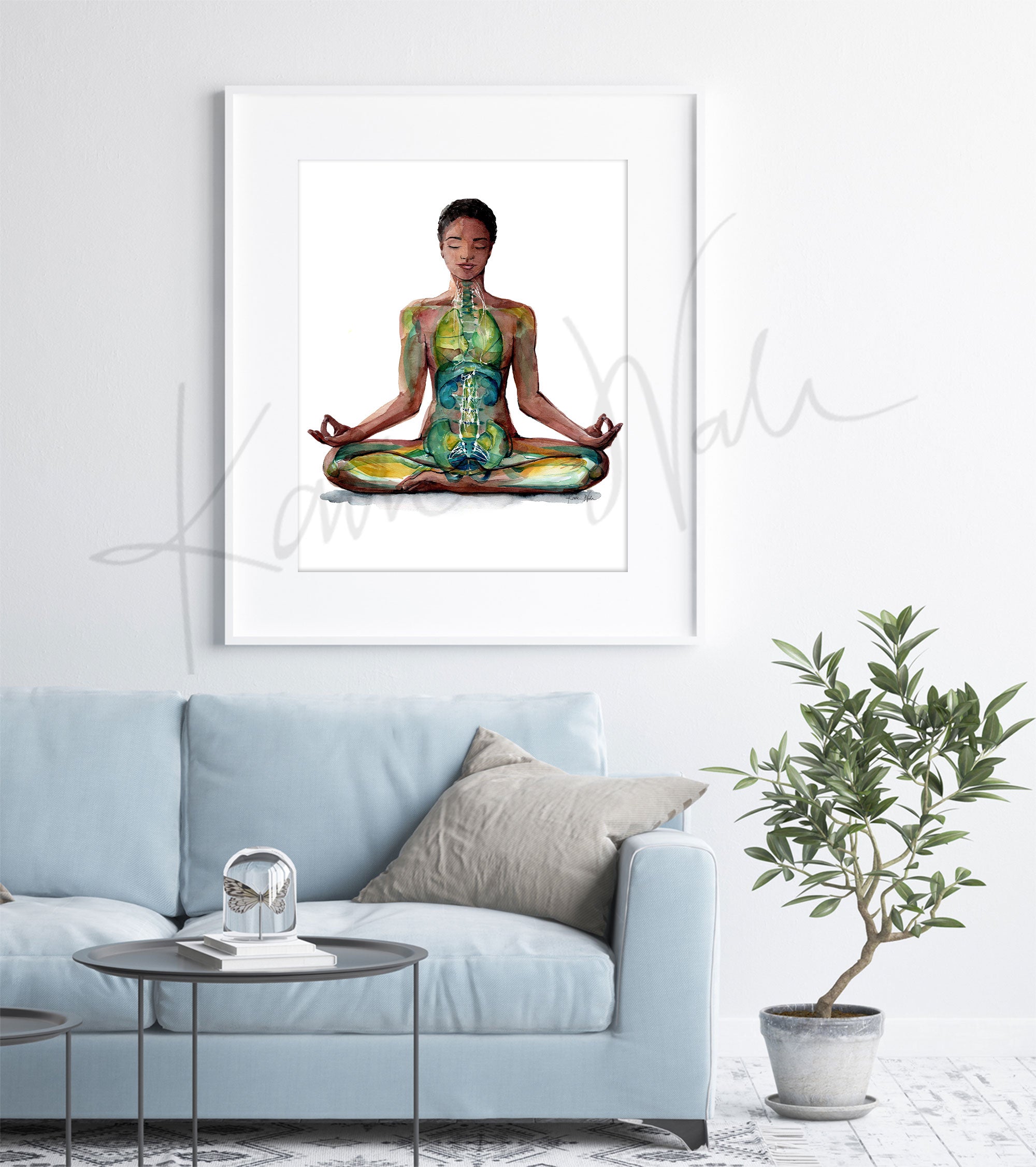 Framed watercolor painting of a painting of a woman of color in a peaceful yoga pose. The painting is hanging over a blue couch.