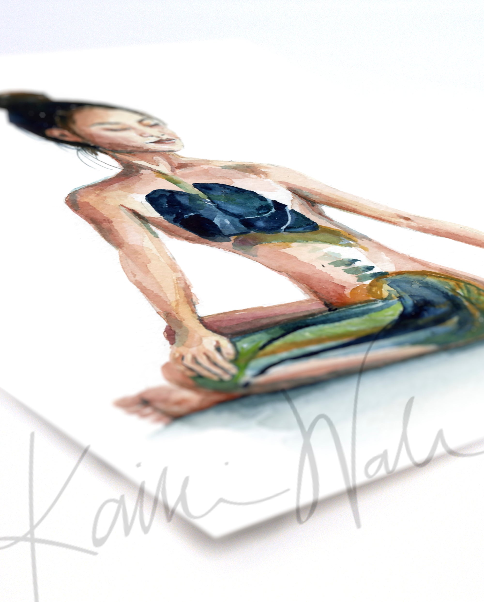 Unframed watercolor painting at an angle of a woman with her eyes closed in a seated yoga pose.